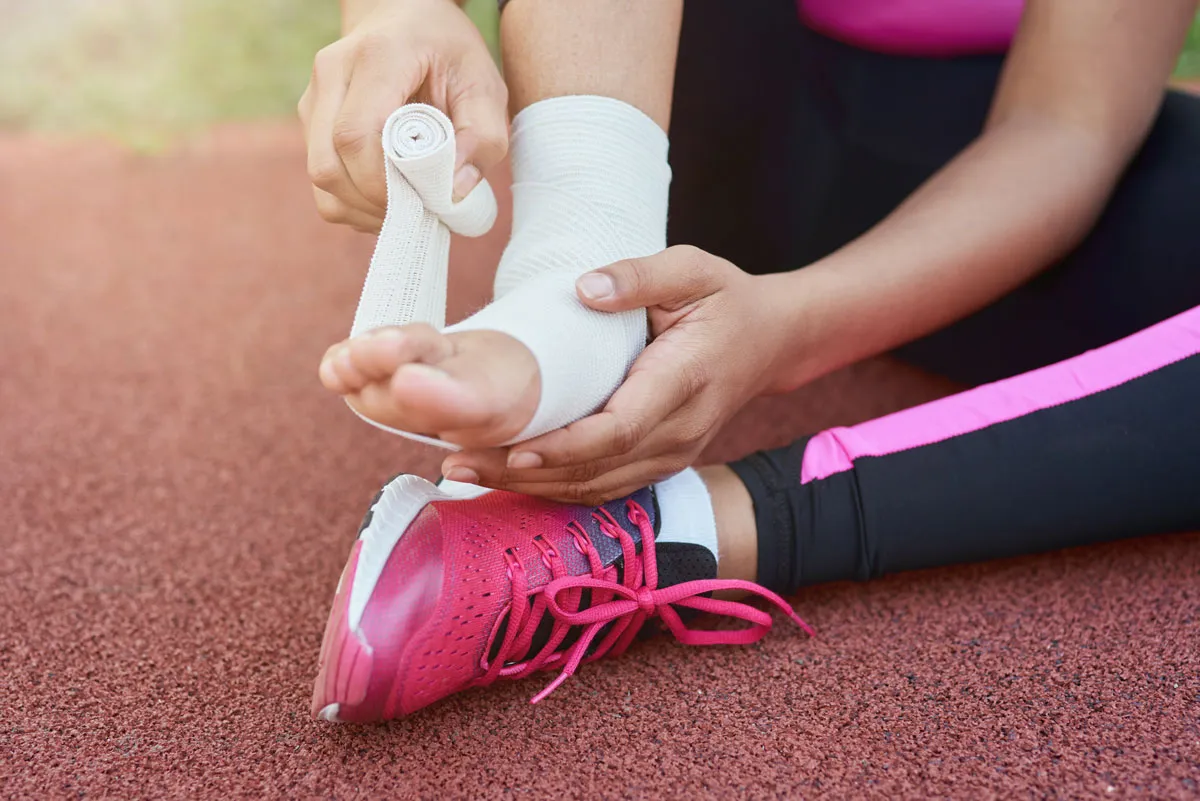 afro american girl putting bandage on injured foot 2023 11 27 05 13 06 utc